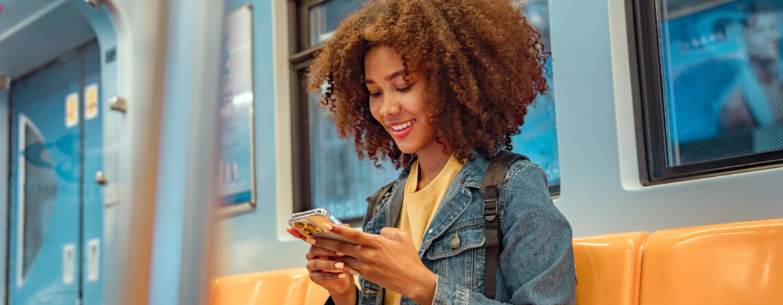 Woman using smartphone for Artificial Intelligence (AI) therapy session while commuting on public transportation