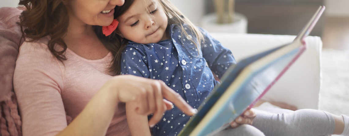 Mom reading book to daughter