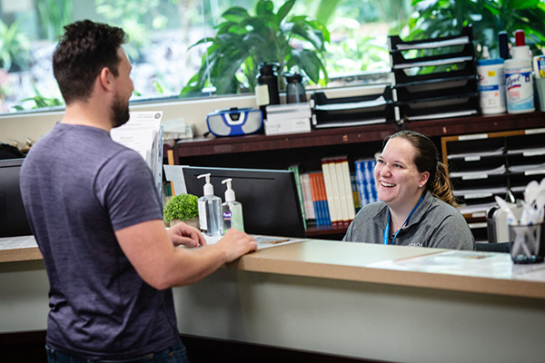 Nystrom receptionist helping patient with mental health services