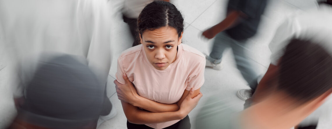 Woman experiences social anxiety in a crowd.